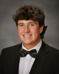 young man in a black and white suit for senior pictures