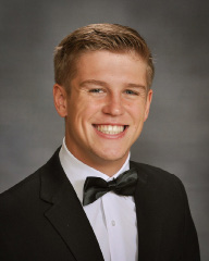 young man in a black and white suit for senior pictures